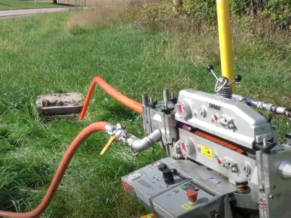 A fiber blowing machine blowing fiber into the ground.
